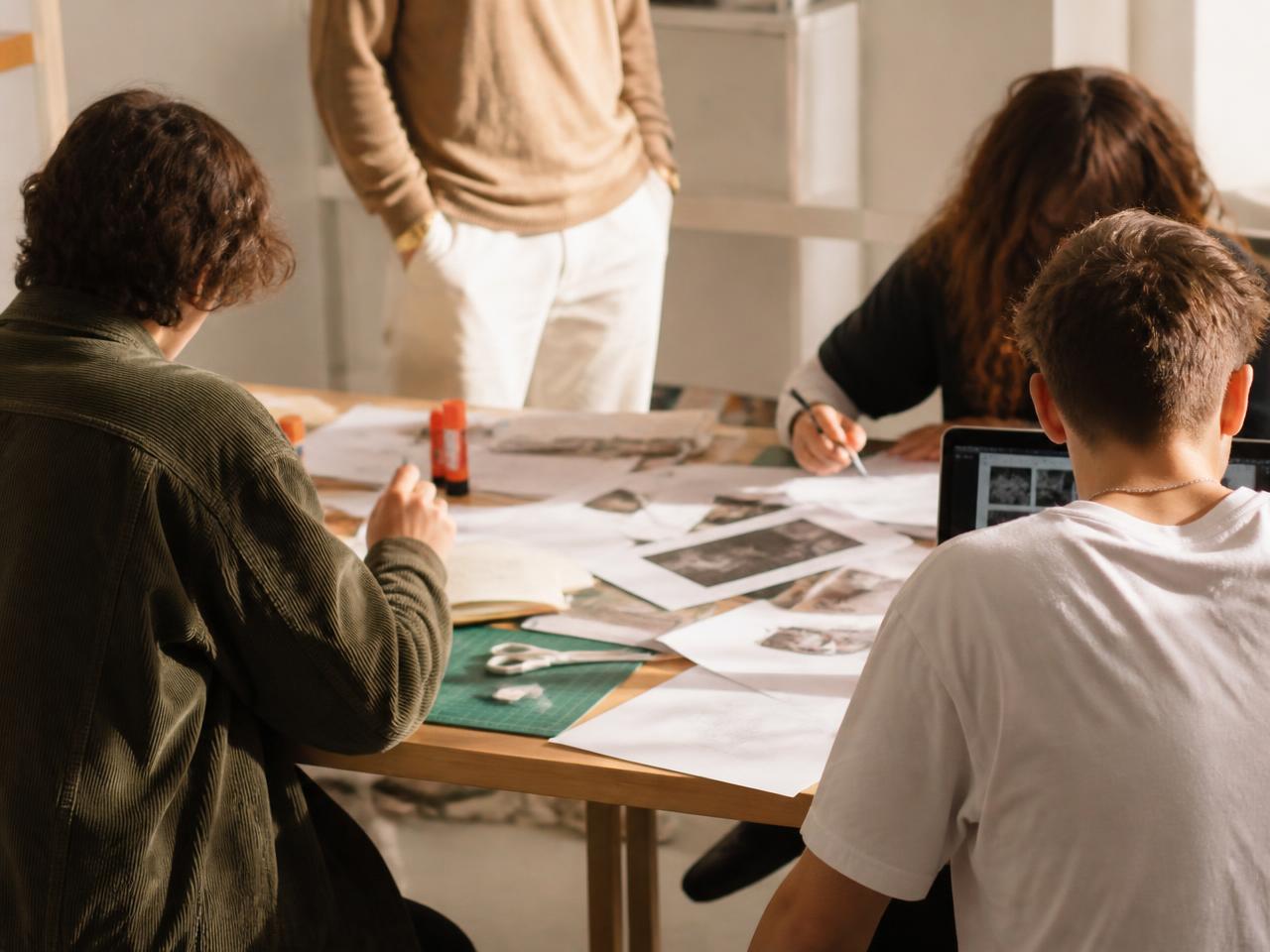 A small supervised club of young people building a project together at a table